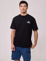 Remera negra de corte suelto, confeccionada en algodón, con pequeño estampado delantero en el pecho y diseño gráfico en la espalda.