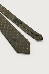 Corbata ancha confeccionada en tejido de seda color verde oliva, con estampado de motivos paisley pequeños en tonos claros y forro interior de seda.