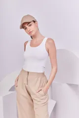 Pantalón recto color beige con cintura elástica y cierre metálico.