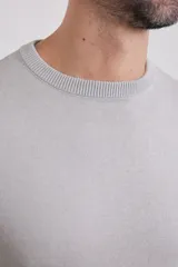 Sweater de punto liso, color azul, con escote redondo y manga larga.