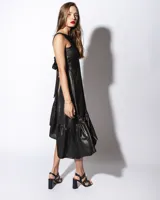 Vestido midi color salmón de tela sedosa, con cuello bote y espalda descubierta con moño.