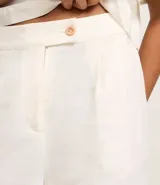 Short de cintura alta confeccionado en mezcla de viscosa y lino, con diseño de pliegues frontales, cierre con botón y bolsillos laterales.