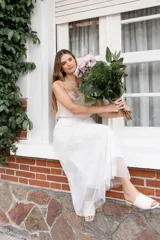 Falda midi de tul color blanco con aplicaciones de perlas distribuidas por toda la prenda, diseño en capas con forro interior y cintura elástica.