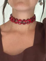 Choker trenzado compuesto por cuentas rectangulares de acrílico con efecto marmolado en tonos rojos. Cuenta con un cierre de cadena de acero quirúrgico ajustable para regular el largo.