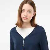Top de punto con textura arrugada, color azul, con escote en pico y cierre frontal con botones pequeños. Presenta mangas largas con diseño acampanado.