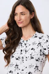 Blusa blanca sin mangas con volados en los hombros, cuello redondo con aberturas y cierre frontal parcial con botones.