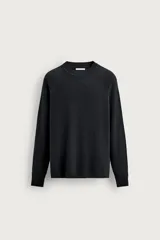 Sweater de punto relaxed fit de color negro, confeccionado con mezcla de lana. Presenta cuello redondo, mangas largas raglán y terminaciones en rib en cuello, puños y dobladillo.