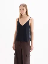 Top blanco de tirantes finos con escote en V y diseño fluido.