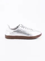 Zapatillas deportivas doradas con suela marrón y cordones al tono.