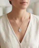 Collar de plata con cadena fina y dije ovalado de la Medalla Milagrosa, rodeado de circonias brillantes.