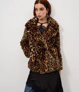 Campera corta de pelo sintético con estampado animal print de leopardo. Presenta un diseño estructurado con cuello amplio y solapas, ideal para un look sofisticado.