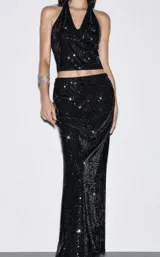 Conjunto de dos piezas compuesto por un top estilo halter con escote en V y una falda larga de corte recto, ambos confeccionados en tela con lentejuelas negras brillantes.