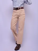 Pantalón de jean color beige, de corte recto y tiro alto, con terminación desflecada en el ruedo.
