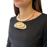 Collar con cadena dorada y colgante con forma de óvalo con tres capas: una base de madera clara, una capa dorada y una piedra ovalada color crema en el centro.