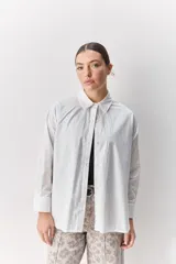 Camisa de algodón de calce relajado con cuello clásico, mangas largas con puños abotonados y cierre frontal con botones.