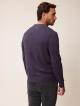 Sweater de punto con cuello redondo, manga larga y puños acanalados. Presenta un pequeño logo bordado en el pecho.