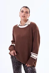 Sweater de punto color marrón con cuello redondo, puños y cuello con detalles de rayas blancas en contraste. De corte holgado y manga larga.
