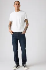 Jean de corte slim fit, color azul oscuro con efecto lavado sutil. Presenta cierre de botones y cinco bolsillos clásicos.