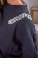 Sweater negro de algodón con cuello redondo y detalle de lentejuelas brillantes en el hombro.