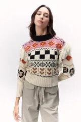 Sweater tejido de punto confeccionado en lana Merino, con diseño multicolor de motivos geométricos y bordados a mano. Presenta flecos en los hombros.