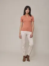 Pantalón color beige de corte recto, con pinzas en la cintura, bolsillos laterales y tobillos ajustados.