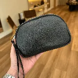 Mini sobre negro de cuero con cierre de cremallera plateada y correa de mano.