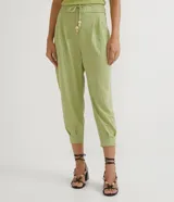 Pantalón jogger verde claro de tejido Orly (malla), con cintura elastizada, pliegues y amarre frontal con cuentas de madera.