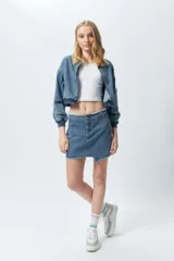 Minifalda de jean negra con corte asimétrico en el frente y deflecado tanto en la cintura como en el ruedo.