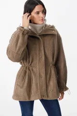 Campera de paño con capucha, cierre frontal con botones a presión y cordones ajustables en la cintura. Presenta mangas largas con puños elásticos y bolsillos laterales.