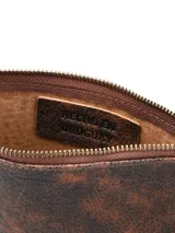 Sobre de cuero marrón con textura rústica, cierre superior con cremallera y correa de muñeca incorporada.