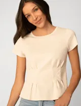 Remera blanca de manga corta con cuello redondo, confeccionada en una mezcla de modal, poliéster y elastano. Presenta un diseño con alforzas verticales en el frente que aportan estructura y una silueta relajada.