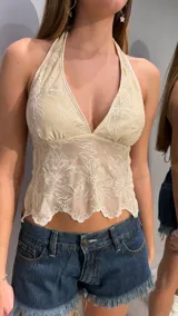 Top halter de tul beige con delicados bordados florales en tono blanco y ruedo festoneado.