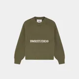 Sweater de punto verde militar confeccionado en tejido grueso acanalado, con calce oversize, cuello redondo y logo bordado en el frente.
