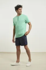 Remera verde con cuello redondo abotonado.