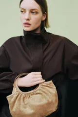Bolso de hombro formato mini shopper confeccionado en piel de ante, con diseño fruncido, doble asa de mano y cierre mediante clip metálico.