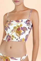Top de bikini con escote recto y breteles finos, presenta un diseño con volado asimétrico en la base y estampado botánico multicolor sobre fondo blanco.