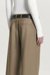 Pantalón de vestir color marrón claro, de lana con pinzas delanteras, corte sastrero, bolsillos laterales y ojal trasero.