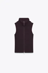 Top de punto canalé en color bordó, sin mangas y con cuello alto. Presenta un cierre frontal completo con cremallera metálica.