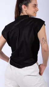 Camisa negra de lino con cuello clásico, manga corta y cierre frontal con botones.