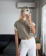 Blusa negra de tela Cey, con cuello mao y escote en V con cierre. Mangas cortas con detalle de encaje marrón en los hombros.