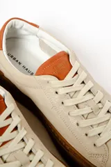 Zapatillas blancas de cuero con detalles en negro en el talón y la lengüeta.