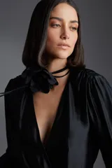 Broche de tela negro con forma de flor.