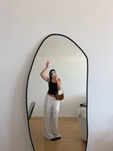 Pantalón negro de algodón y viscosa, con estampado de lunares blancos y corte holgado.