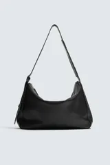 Bolso de hombro de diseño minimalista confeccionado en piel de alta calidad. Cuenta con un compartimento principal con cierre de cremallera, interior con bolsillos organizadores y asa de hombro fija. Incluye un detalle de llavero colgante.