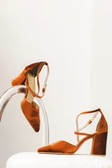 Zapato de tacón ancho color rosa viejo, de tela tipo terciopelo, con puntera fina y tiras cruzadas sobre el empeine.