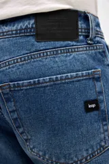 Jean de corte recto y tiro medio, en color azul clásico con acabado lavado. Presenta cierre de cremallera y botón metálico, con diseño de cinco bolsillos.