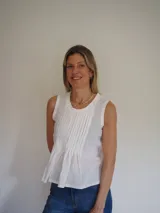 Blusa sin mangas de algodón color blanco, con delicadas tablas en el frente y terminaciones levemente desflecadas, de corte suelto y liviano.