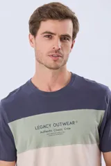 Remera Legacy Outwear de algodón y poliéster, de diseño moderno con bloques horizontales en tonos azul, verde militar y beige, y estampa tipográfica frontal.