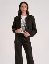 Camperita tipo bomber marca Elan en color negro, con cuello a la base y cierre frontal de botones. Presenta bolsillos delanteros con solapa y terminaciones en rib elástico en cuello, puños y cintura.