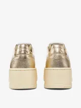 Zapatillas de plataforma Autry Medalist, con diseño inspirado en el tenis de los años 80. Presentan una combinación de cuero blanco y cuero laminado color platino, con microperforaciones en la puntera para mayor transpirabilidad y suela de plataforma alta en tono crema.